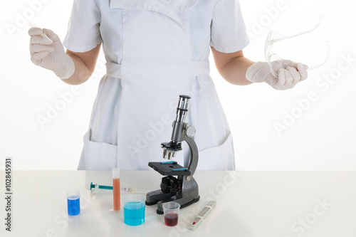 Young female technical assistant tunes her microscope photo