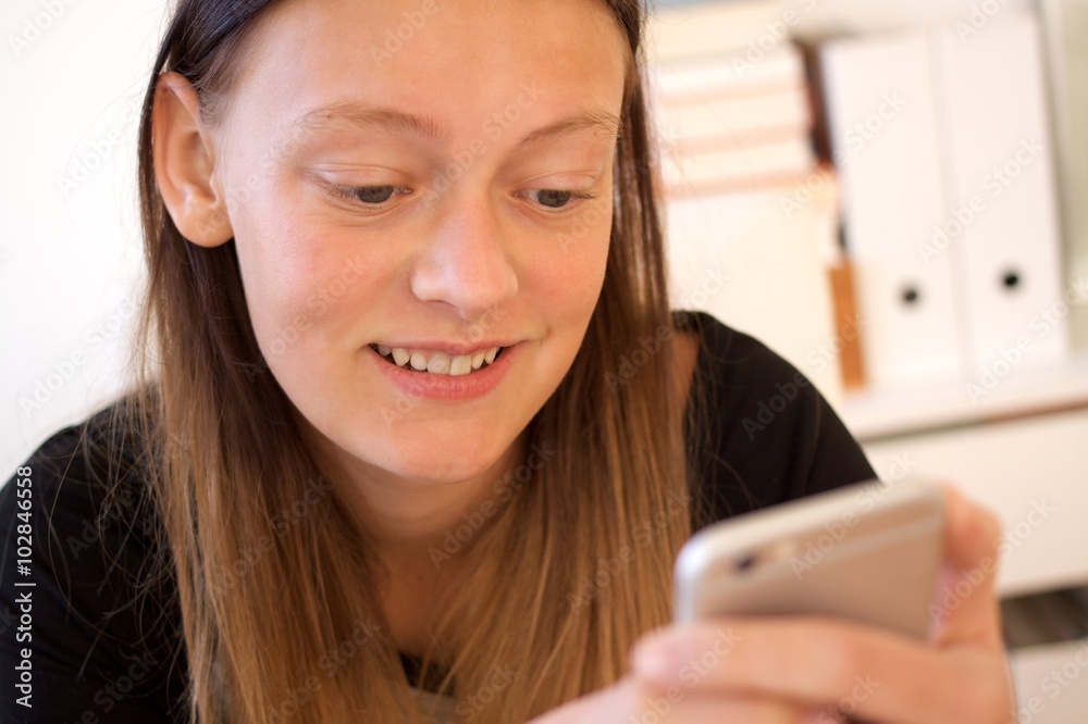 Lächelnder Teenager hält Smartphone in der Hand Lächelnder Teenager hält Smartphone in der Hand