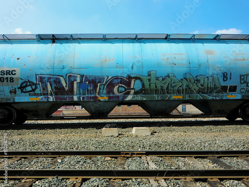 Blue industrial train car with tracks - landscape color photo
