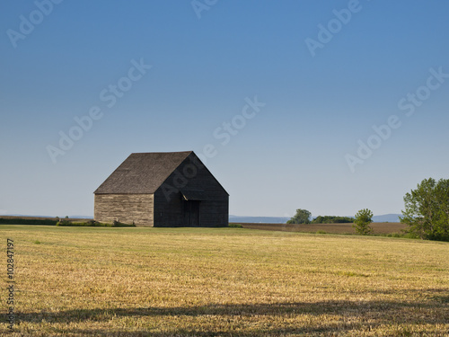 Old Dutch Barn: An old wooden Dutch barn in a golden field in New York state.