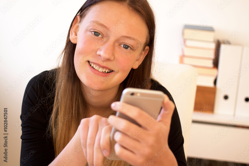 Fröhlicher Teenager hält Smartphone in der Hand Fröhlicher Teenager hält Smartphone in der Hand