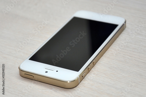 Blank screen mobile phone on wood background