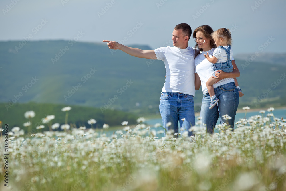 happy family in a camomile field 