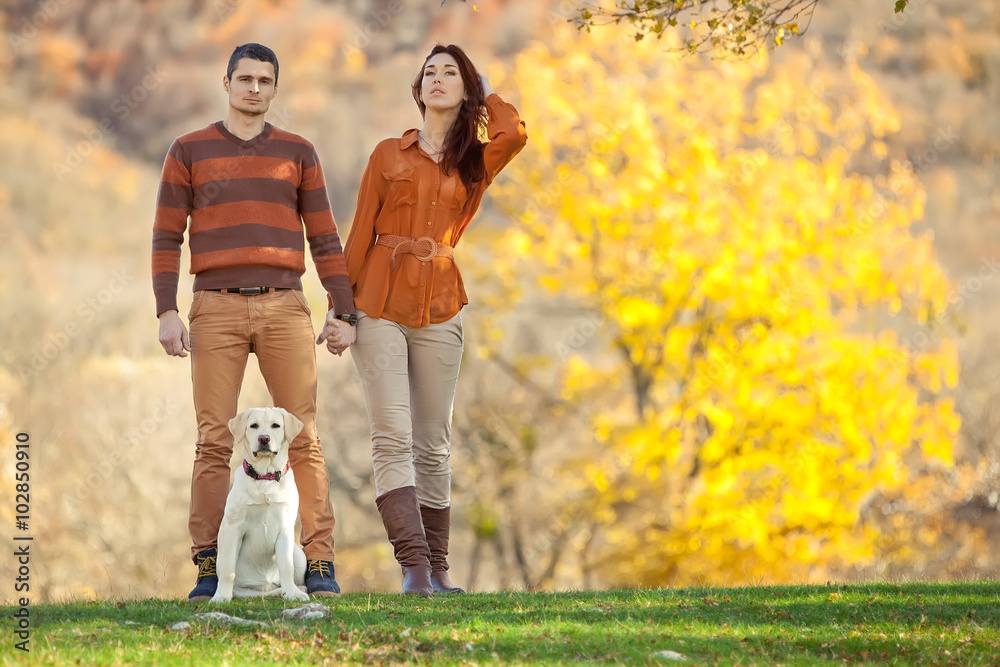 Fototapeta premium Two lovely people are walking on the nature with labrador