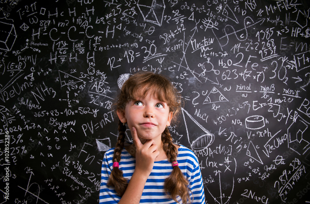 Girl thinking, finger on cheek, blackboard with mathematical sy Girl thinking, finger on cheek, blackboard with mathematical sy