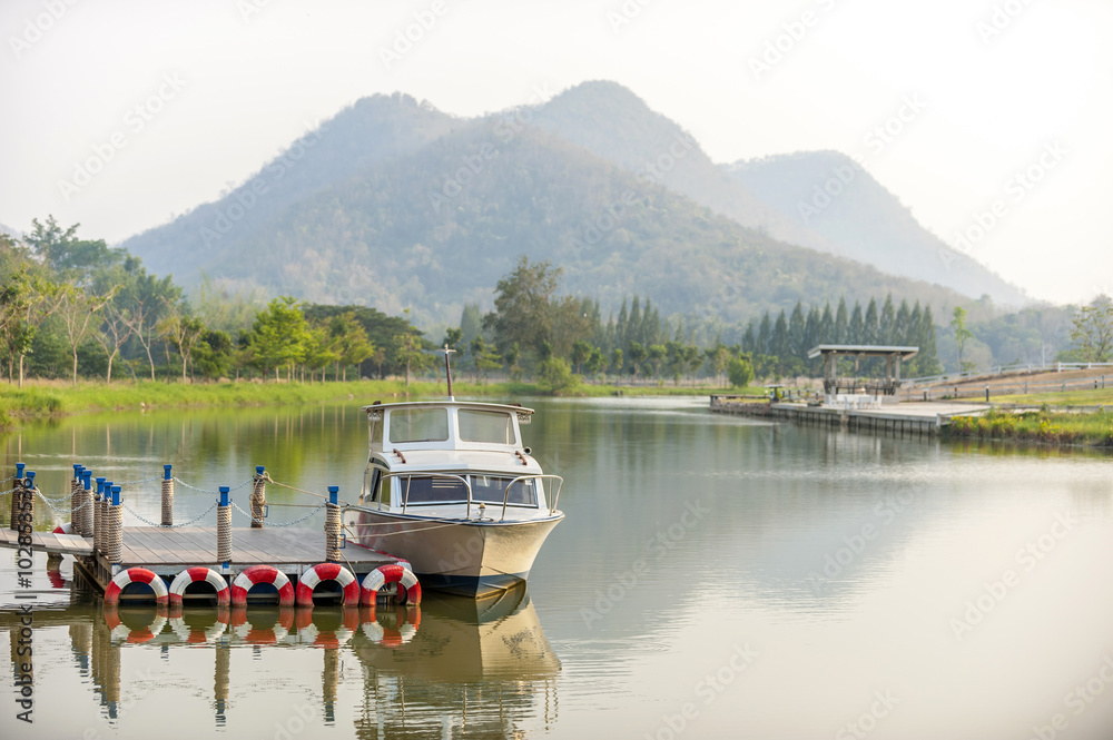 vacation, travel and sea concept - white boat at blue lagoon on moutain background, Thailand