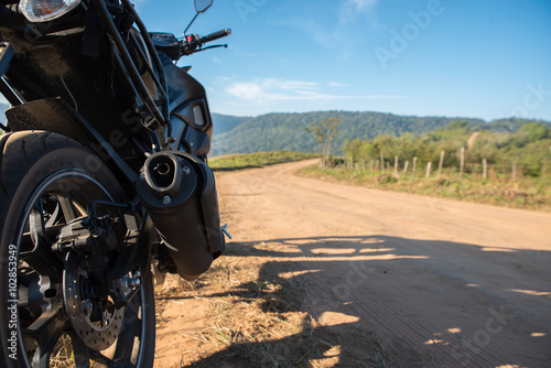 Motorcycle and dirt road.