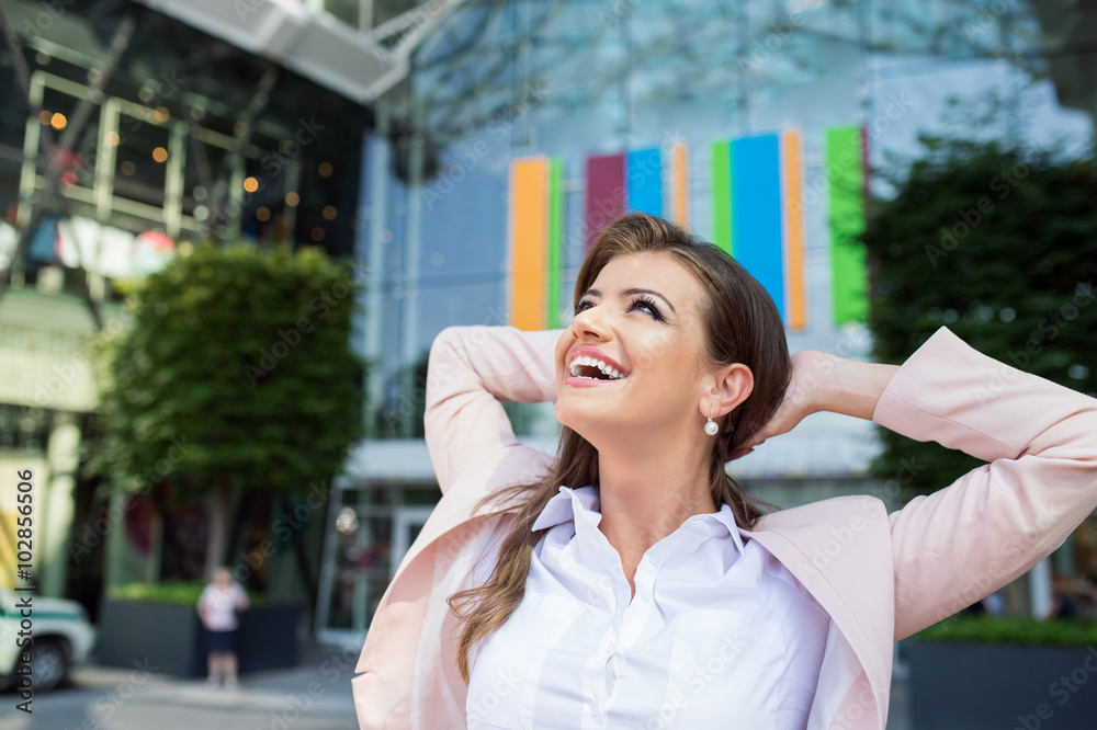 Smiling businesswoman with hands on head against modern building Smiling businesswoman with hands on head against modern building