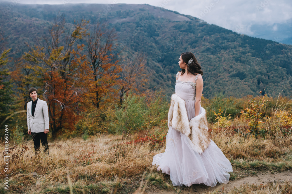 happy newly married couple posing in the mountains