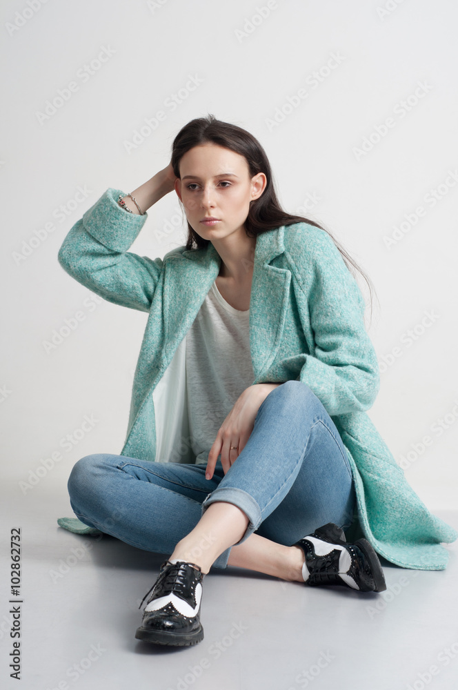 Close up portrait. Young girl sitting. Isolated on a grey background
Close up portrait. Young girl sitting. Isolated on a grey background