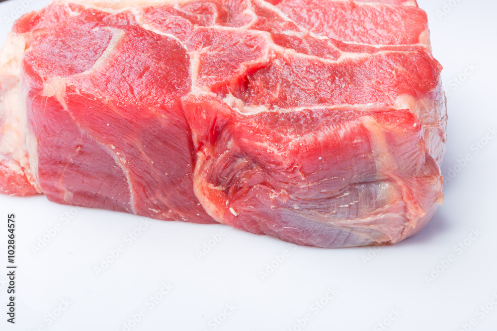 one piece of raw beef meat with the bone in the middle on a white background