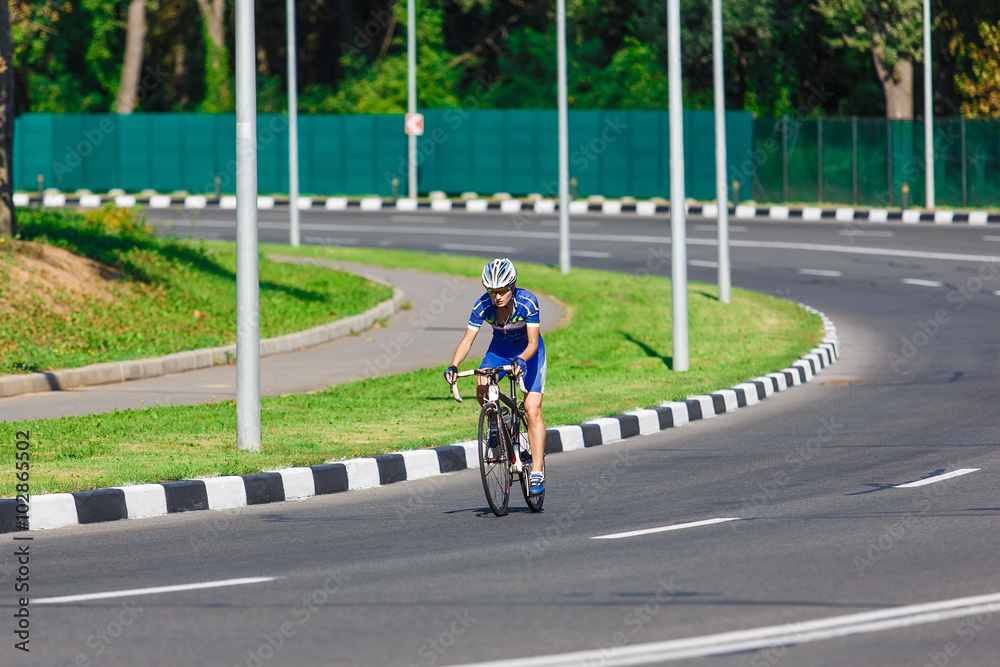 Female cyclist rides a racing bike on road