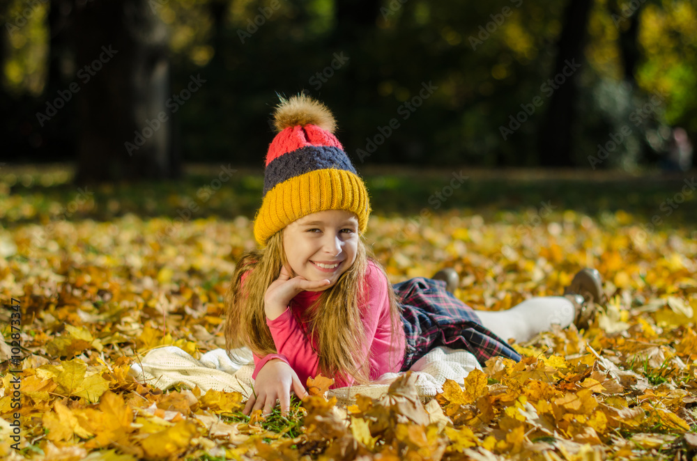 Pretty smiling girl lying on yellow leaves Pretty smiling girl lying on yellow leaves