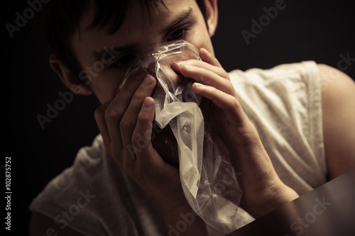 Teen inhaling narcotics from plastic bag