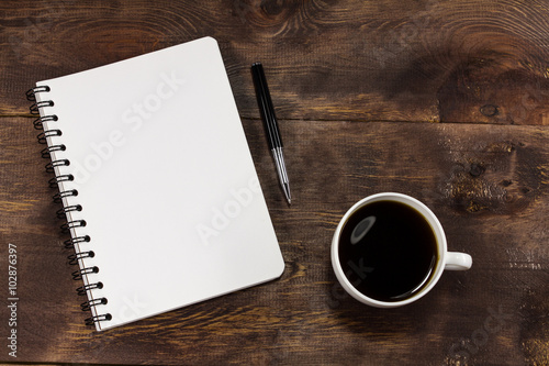 Coffee cup with a note book and a pen