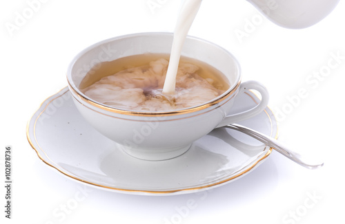 Milk poured in a cup of tea