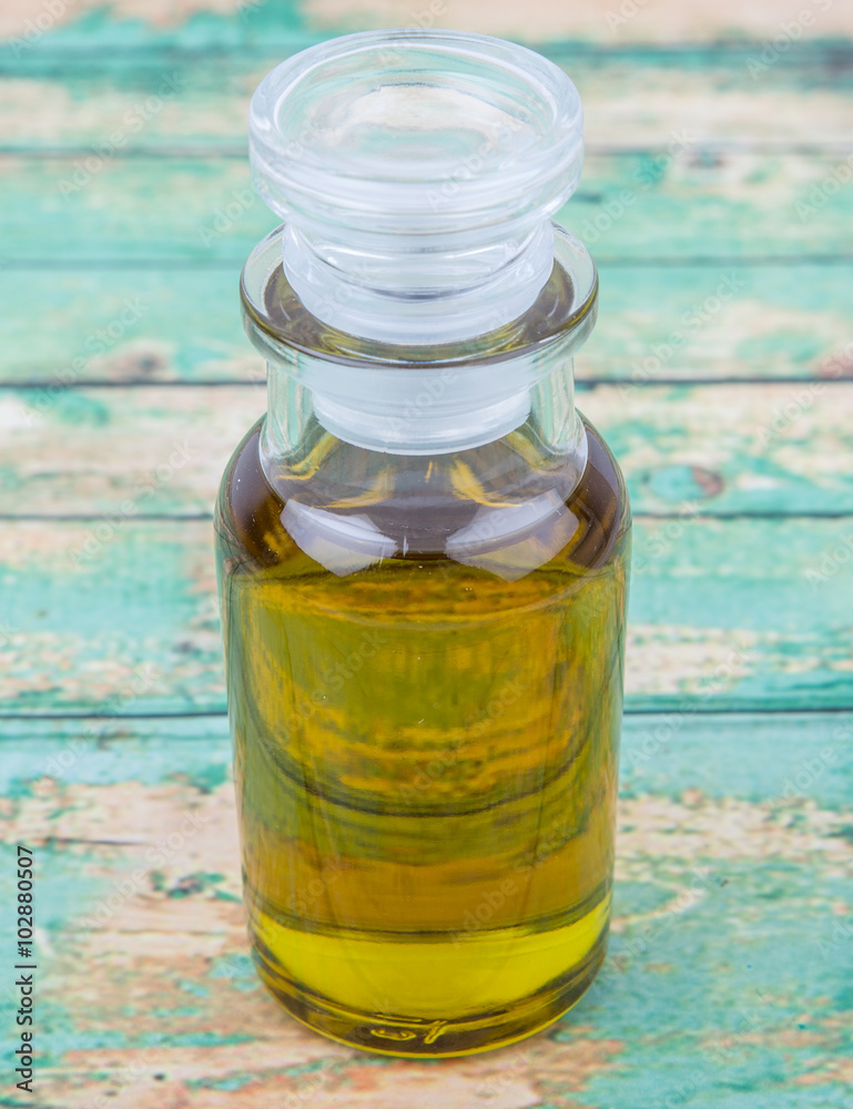 Avocado oil in glass vial over wooden background Avocado oil in glass vial over wooden background