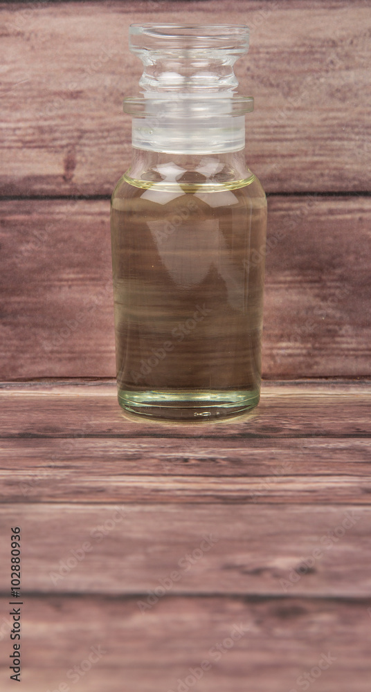 Corn vegetable cooking oil in vial glass over wooden background Corn vegetable cooking oil in vial glass over wooden background