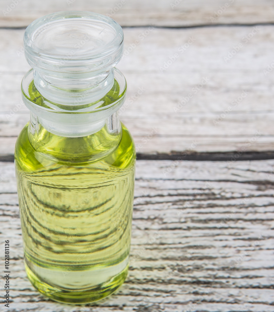 Grape seed oil in glass vial over wooden background Grape seed oil in glass vial over wooden background