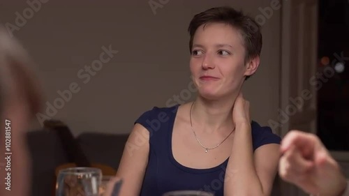 Young Russian woman in a dinner with friends. She is talking and smiling. The camera moves and focus changes to the man at foreground. 4K, UHD