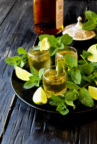 Glass of whiskey with mint and lemon