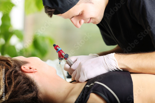 Tattooist makes tattoo, clo...
