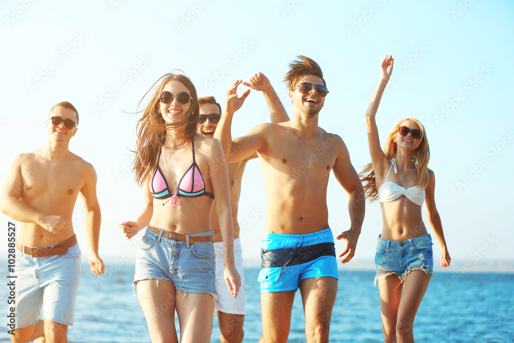 Happy friends running at the beach, outdoors Happy friends running at the beach, outdoors