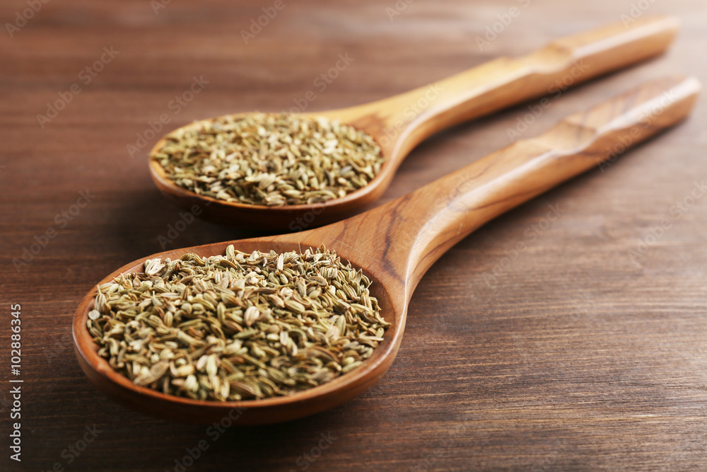 Two wooden spoons with cumin on the table, close-up Two wooden spoons with cumin on the table, close-up