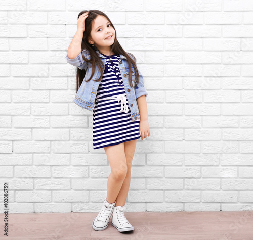 Little girl on a white bric...