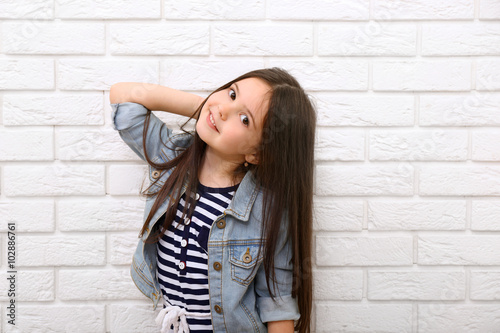 Little girl on a white bric...