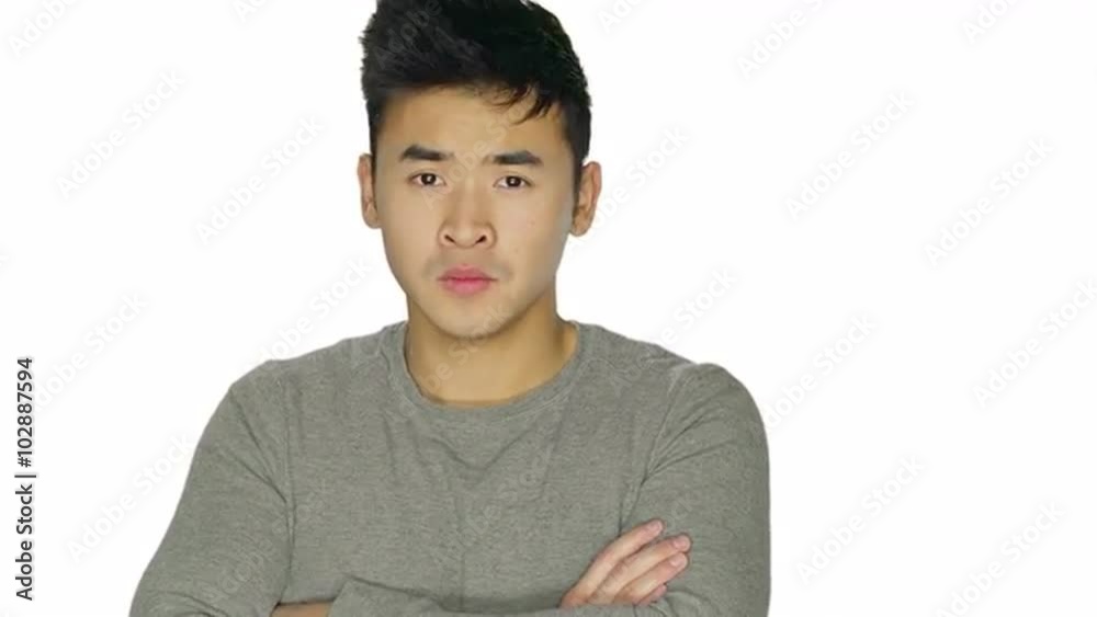 Handsome young man looks stern and serious and then starts dancing, on a white studio background Handsome young man looks stern and serious and then starts dancing, on a white studio background