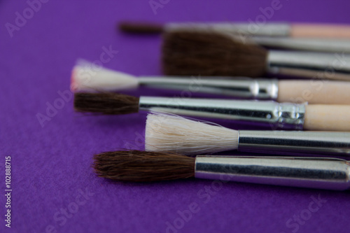Used different size paint brushes closeup over purple background