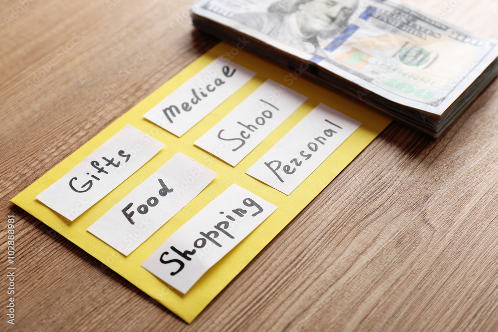 List of needs and cash on wooden background List of needs and cash on wooden background