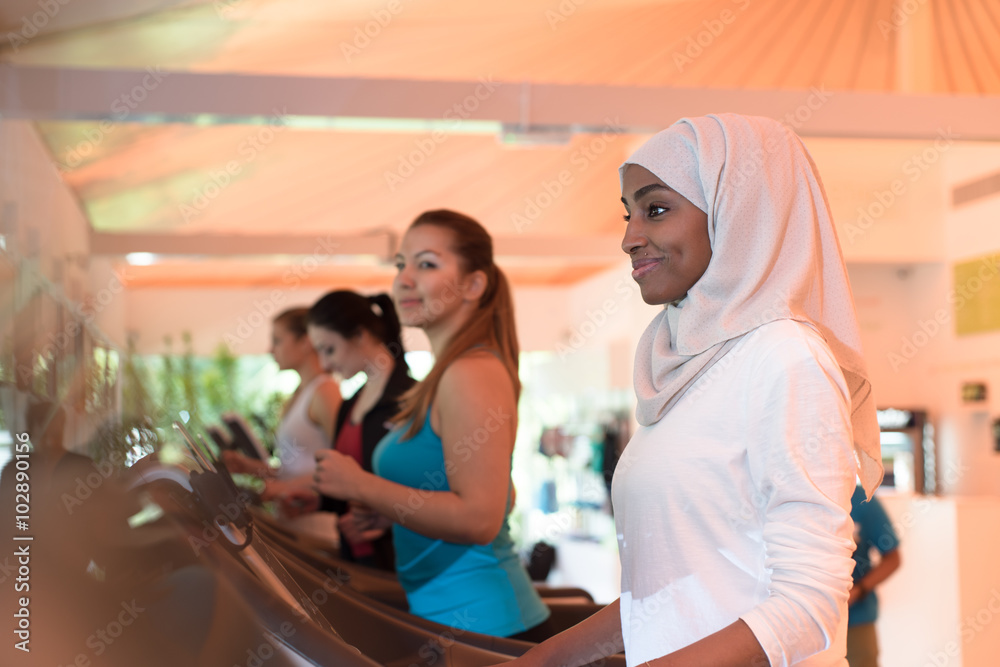 Φωτογραφία Muslim Girl Practicing Sports in Gym Together with Other Women