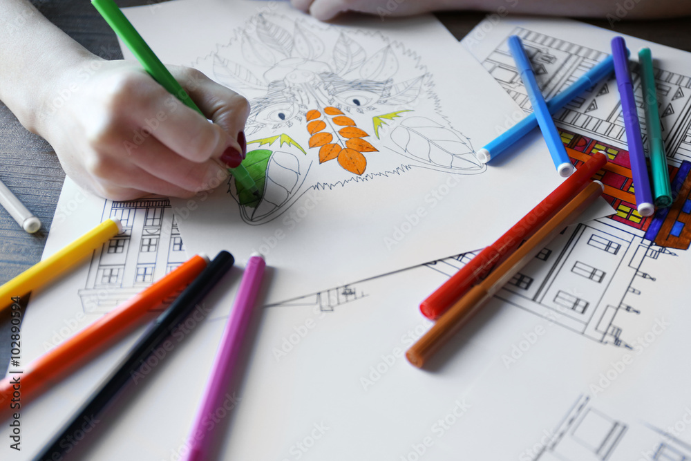 Female hand painting anti stress colouring with green felt pen Female hand painting anti stress colouring with green felt pen