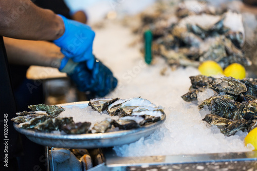Tableau sur toile close-up of shucking oysters