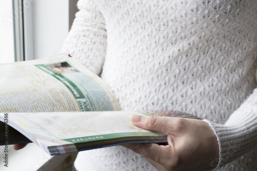 Woman leafing through magazine