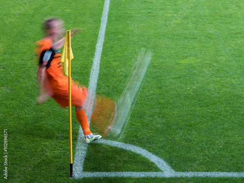 Soccer player kicks a ball from a corner kick - intentional blur.