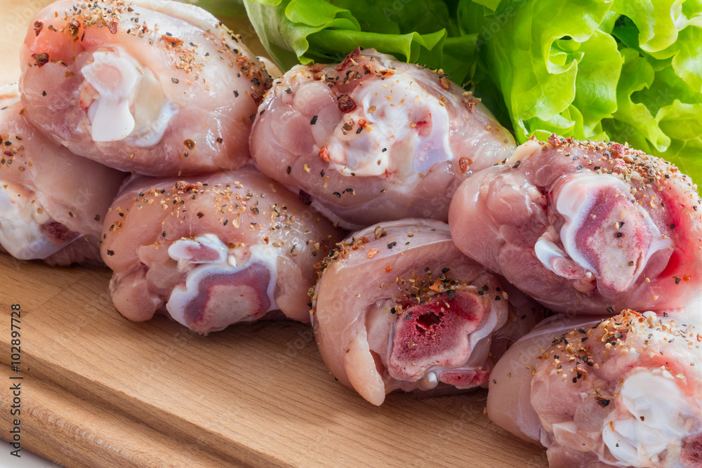 Raw Chicken Drumsticks with salad and pepper