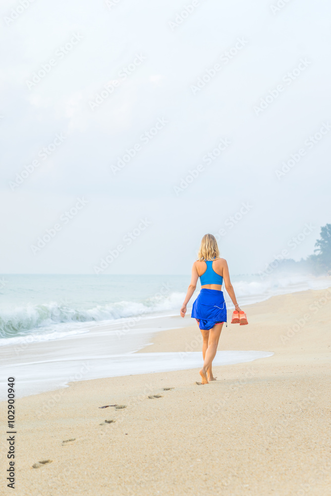 woman walking on sand beach leaving footprints in the sand. woman walking on sand beach leaving footprints in the sand.