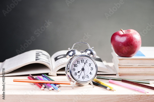 School books with apple on desk 