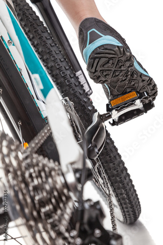 Close up rear view cyclist pedalling mountain bike isolated on white background. Studio shot.