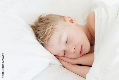 boy sleeping in white bed