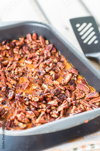 Homemade Mashed Sweet Potato Casserole with Caramelized Pecans for Thanksgiving Day, Vertical, Close-up photo