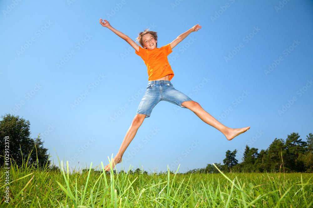 Boy jumping on the sunny meadow in a summer Boy jumping on the sunny meadow in a summer