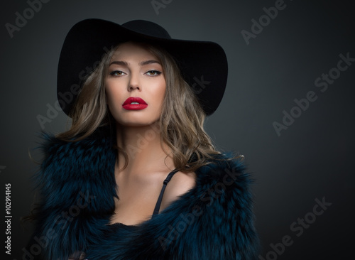 Woman in hat on a dark background studo shot photo