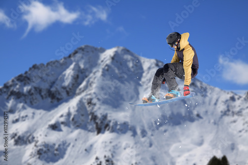 Flying snowboarder on mountains. Extreme sport.