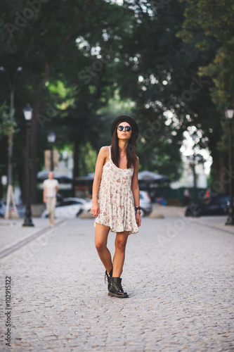 young woman wearing dress posing on street