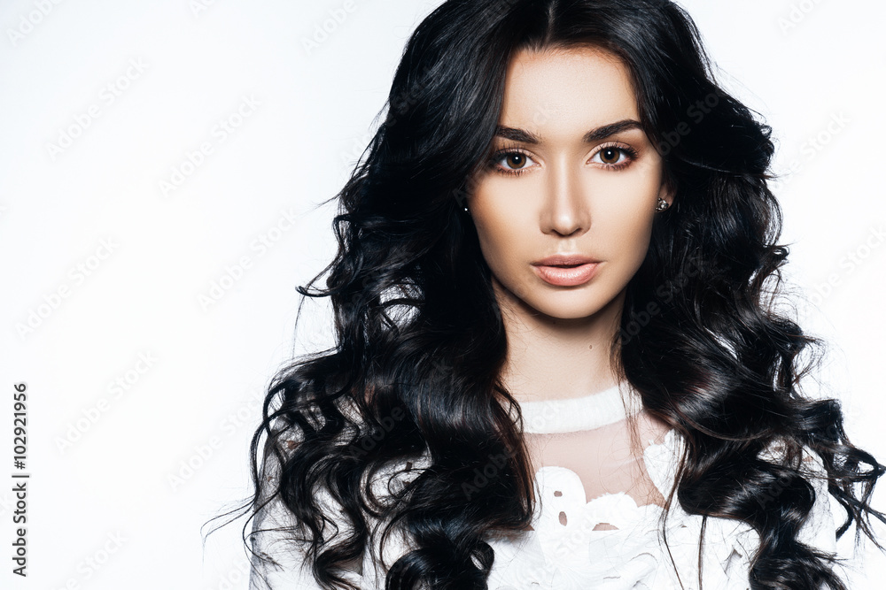 Fototapeta premium beautiful girl brunette model with hair and natural makeup in a white blouse on a white background