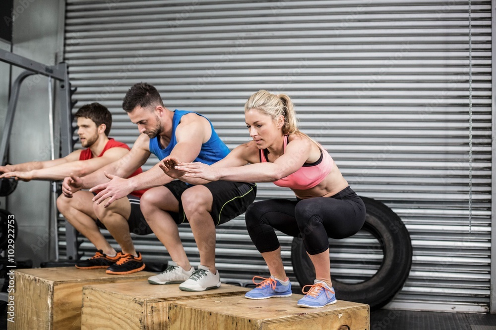 Fototapeta premium Fit people doing exercises with box